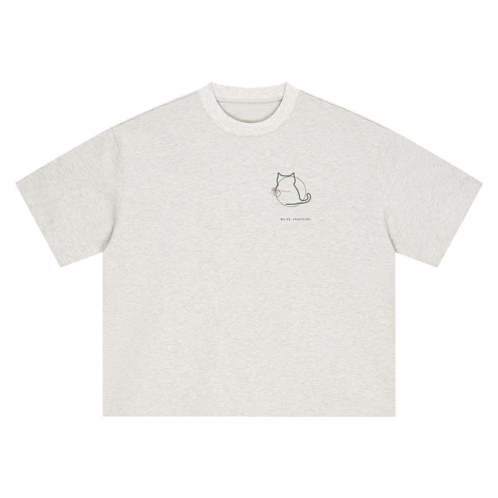 Front of a boxy heavyweight tee in Oat Gray with a small sitting-cat epicycle drawing on the left chest.